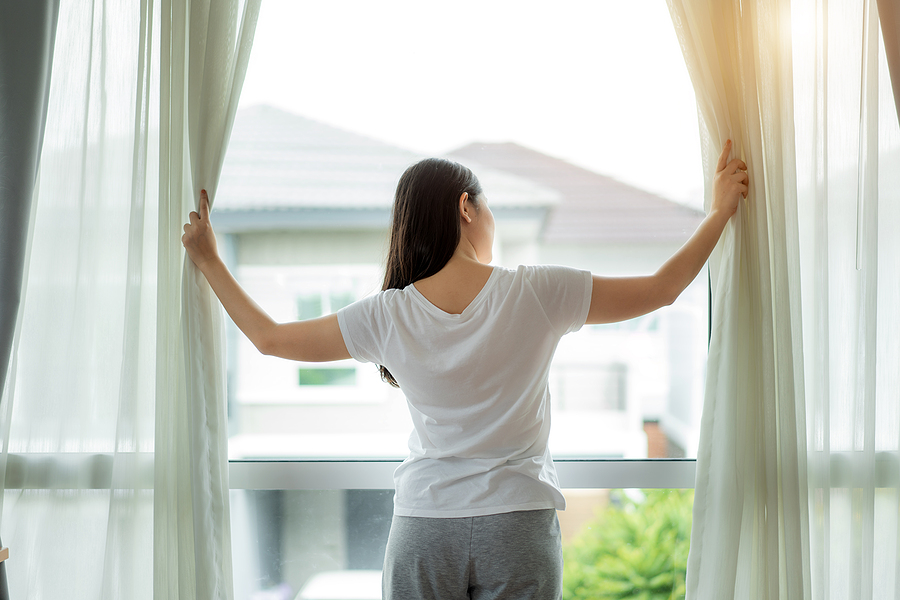 Woman opening curtains and blinds in Adelaide
